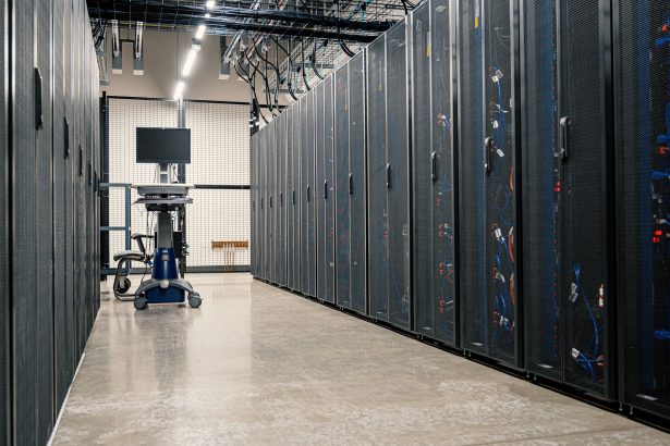 Gabinetes metálicos com servidores, equipamentos de rede e cabos em um datacenter moderno