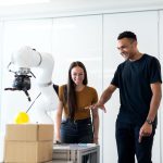Dois engenheiros colaboram no teste de um protótipo robótico em um laboratório moderno.