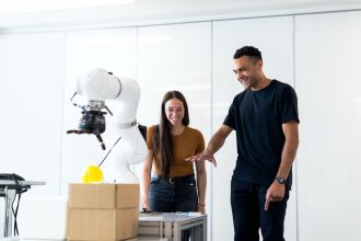Dois engenheiros colaboram no teste de um protótipo robótico em um laboratório moderno.