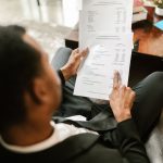Profissional analisa documentos financeiros sobre uma mesa em um ambiente de escritório.