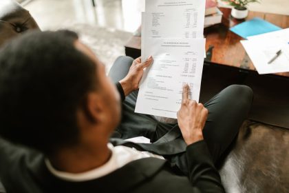 Profissional analisa documentos financeiros sobre uma mesa em um ambiente de escritório.