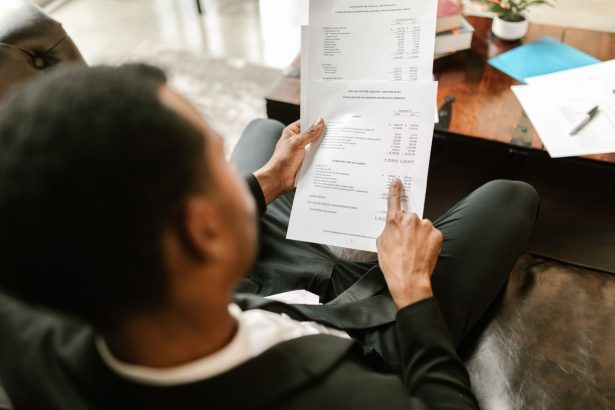 Profissional analisa documentos financeiros sobre uma mesa em um ambiente de escritório.