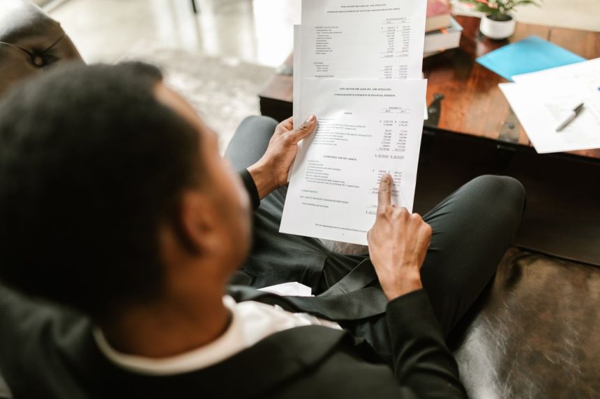 Profissional analisa documentos financeiros sobre uma mesa em um ambiente de escritório.