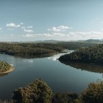 Rio sinuoso cercado por mata, em uma paisagem de Minas Gerais.