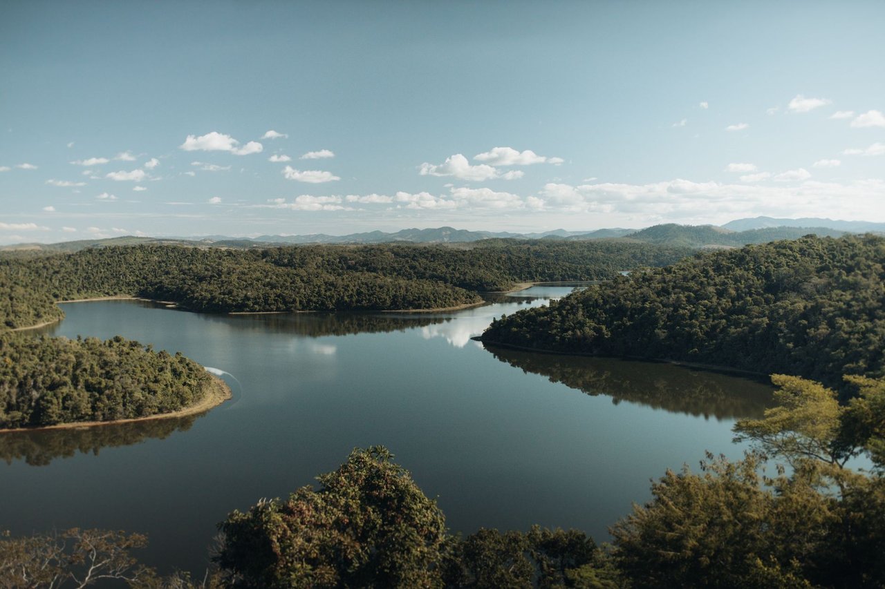 Rio sinuoso cercado por mata, em uma paisagem de Minas Gerais.